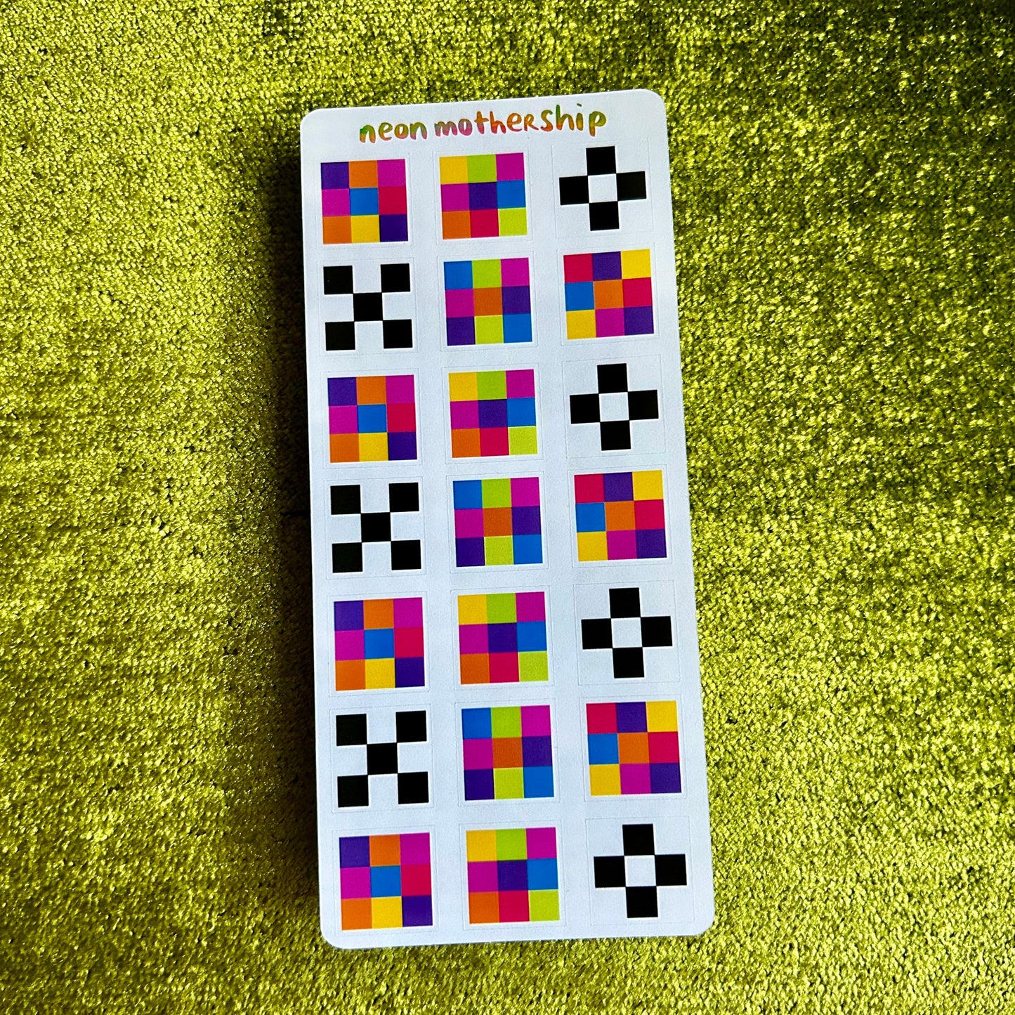 Sticker sheet with colorful geometric patterns on a green textured background