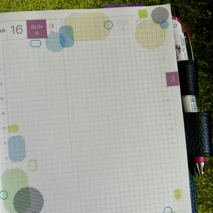 Notebook with colorful geometric patterns on a grassy background