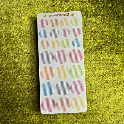 Pack of colorful round stickers on a green textured background