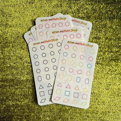 assorted sticker sheets with geometric pattern designs on a green textured surface
