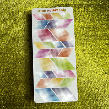 sticker sheet with geometric patterns on a green textured surface