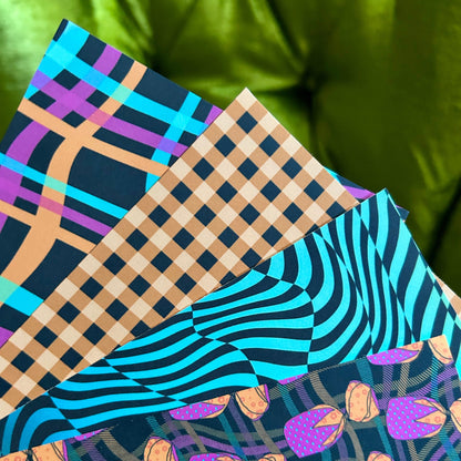Four sticker sheets with different patterns on a green background