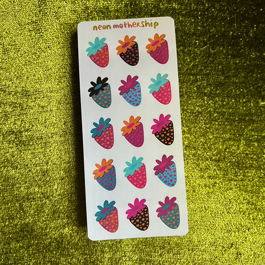 Sheet of colorful strawberry-shaped stickers on a green textured background