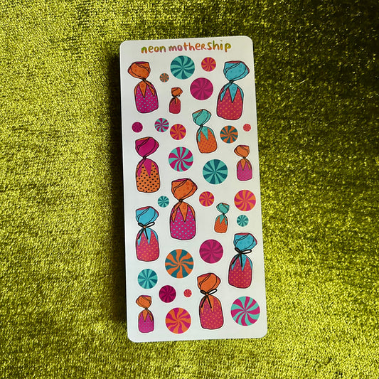 Sticker sheet with colorful designs on a green textured surface