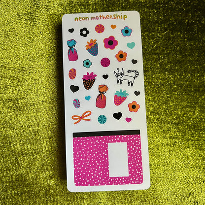 Sticker sheet with colorful designs on a green textured surface