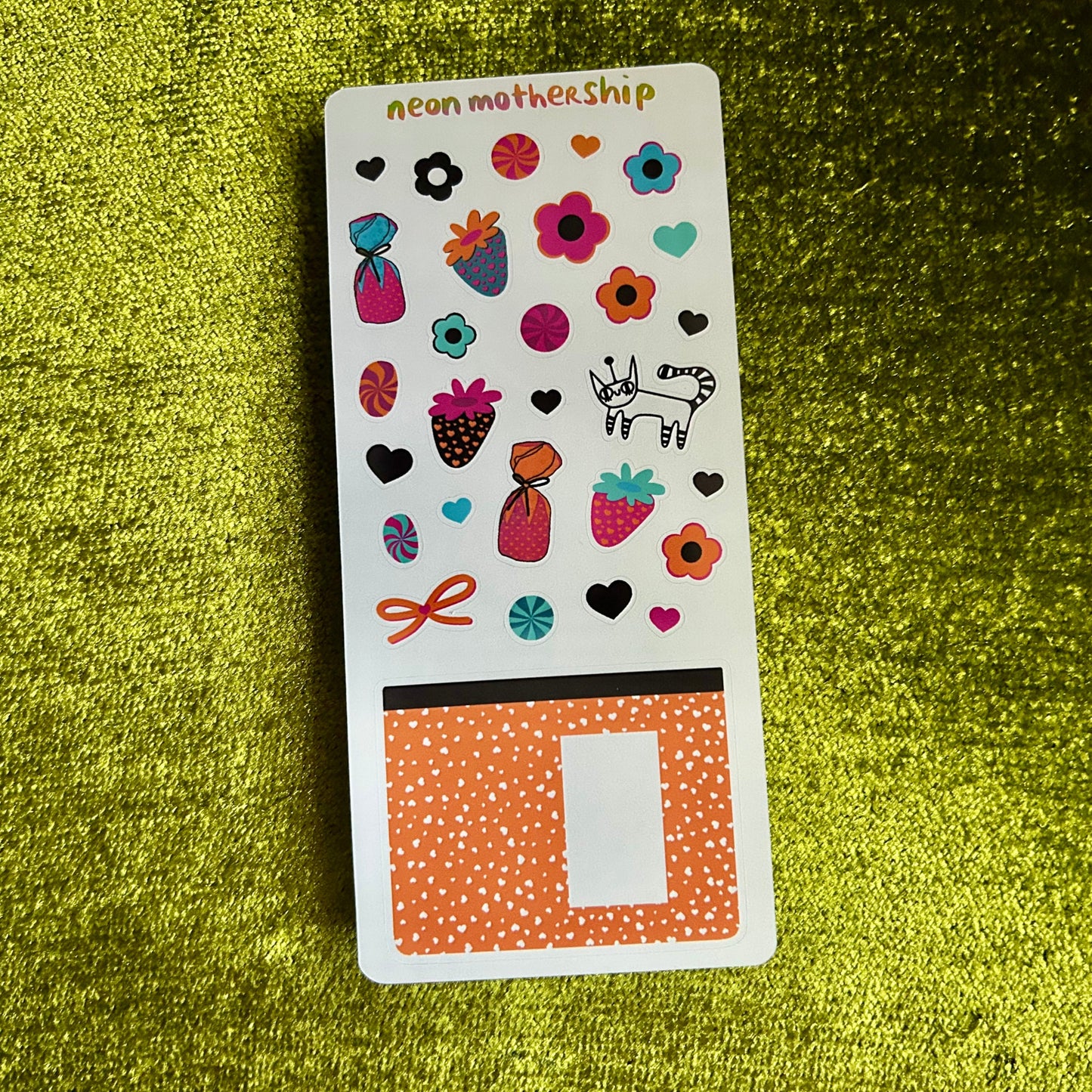 Sheet of colorful stickers on a green textured surface