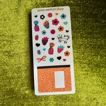 Sheet of colorful stickers on a green textured surface