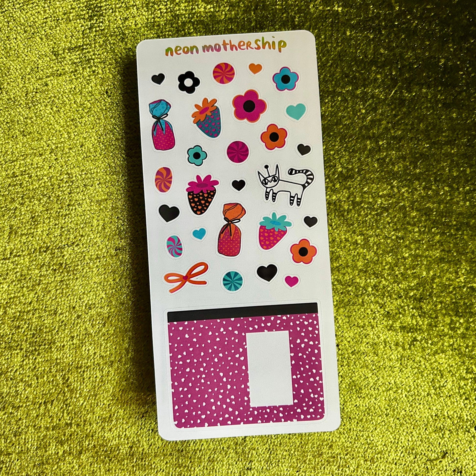 Sticker sheet with colorful designs on a green textured background