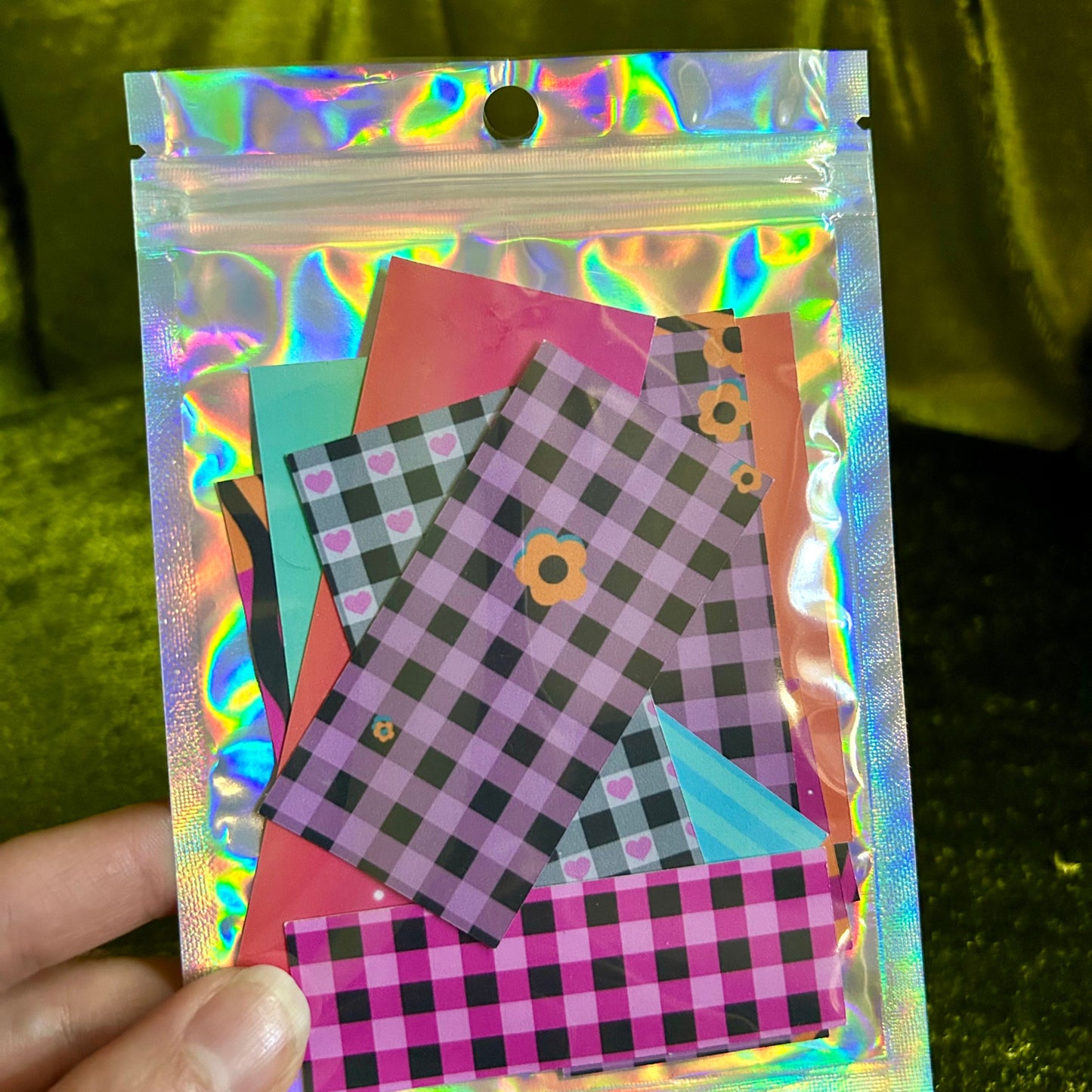 Holographic bag with checkered paper inside against a green background
