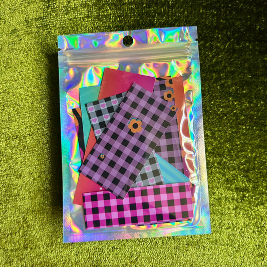 Holographic package with checkered sticker scrap samples on a green textured background