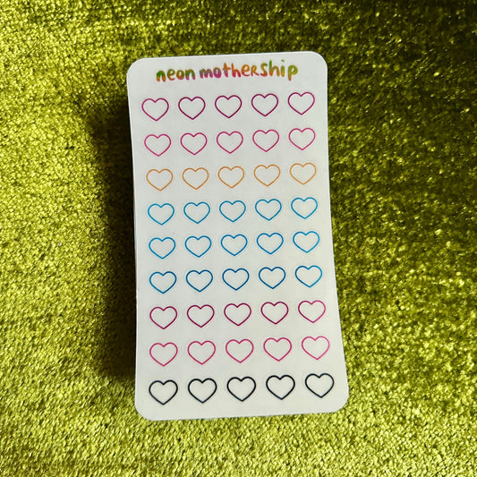Sheet of heart-shaped stickers with 'neon mother ship' branding on a green textured background