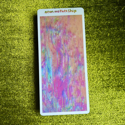Colorful card with 'neon mothership' text on a green textured surface