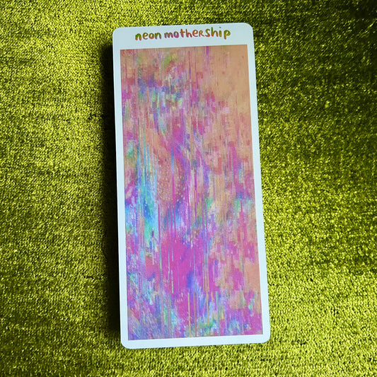 Colorful card with 'neon mothership' text on a green textured surface