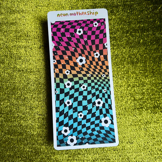 Colorful patterned card with 'neon motherShip' text on a green textured surface