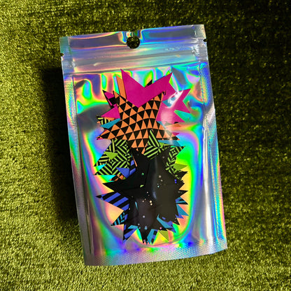 Holographic pouch with geometric design on a green textured surface