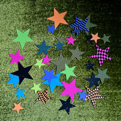 Colorful star-shaped papers on a green textured surface