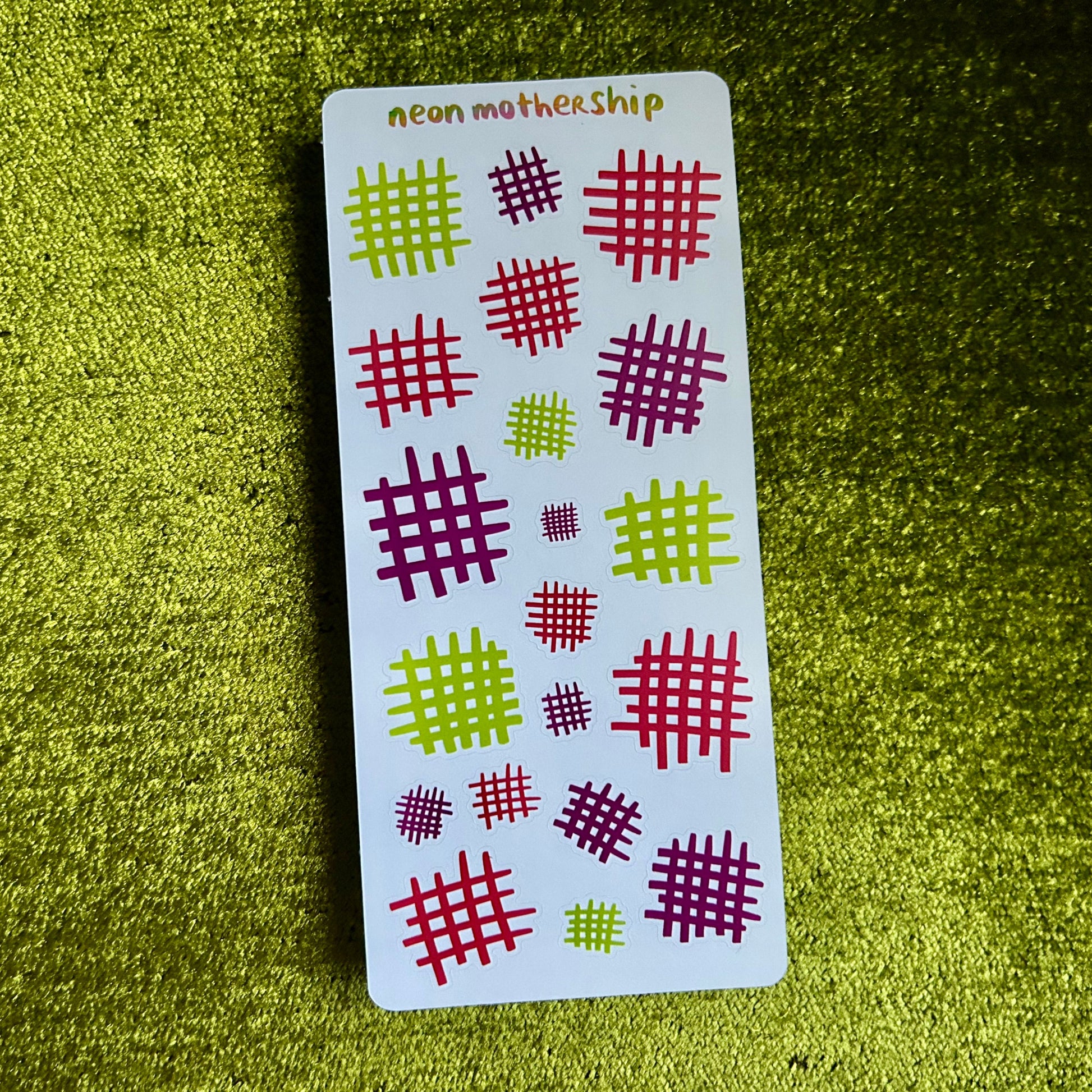 Card with red and green checkered patterns on a green textured surface