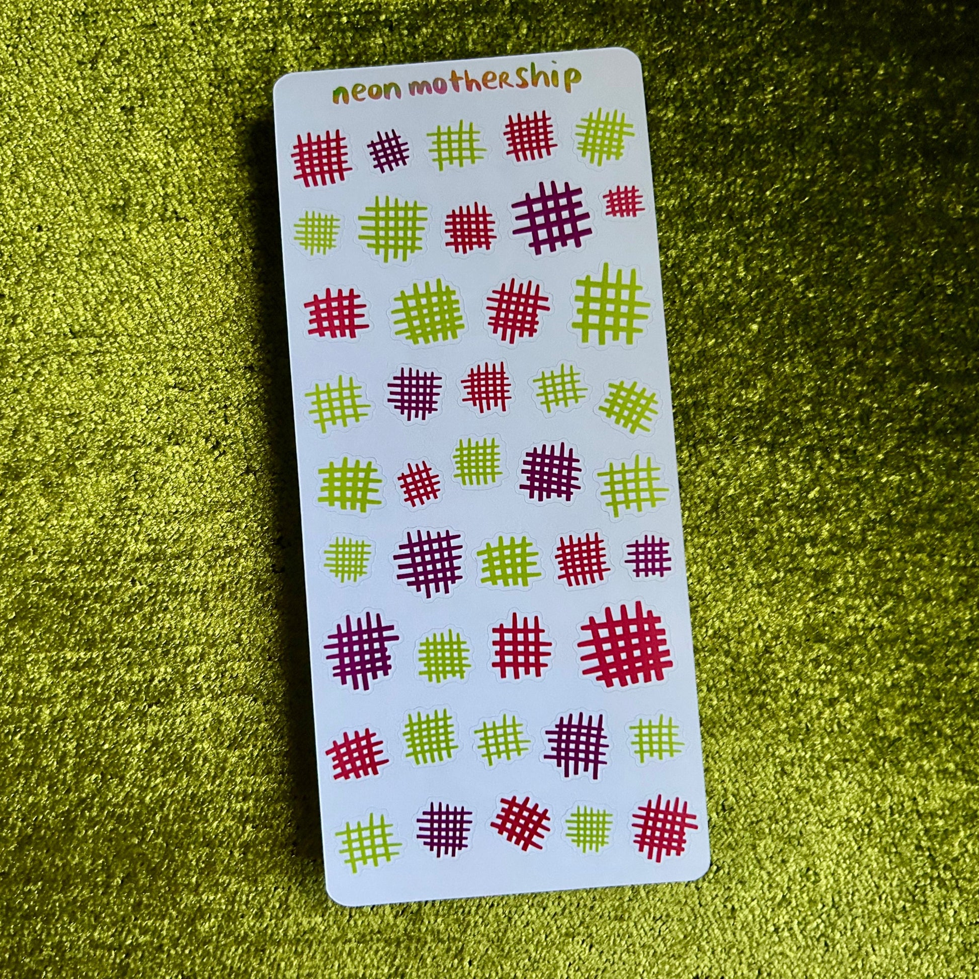 Card with red and green pattern on a green textured surface