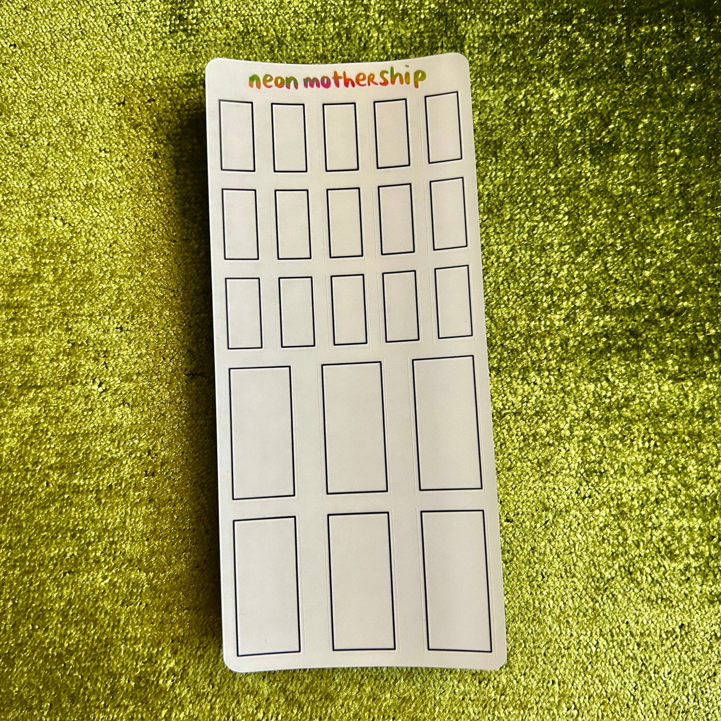 sticker sheet with rectangular outlines on a green textured surface