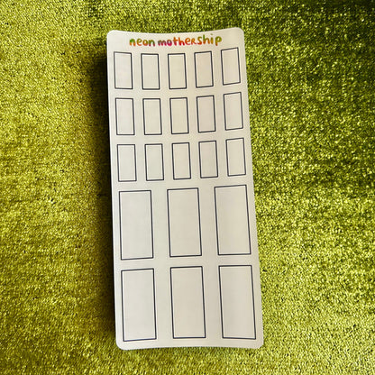 sticker sheet with rectangular outlines on a green textured surface