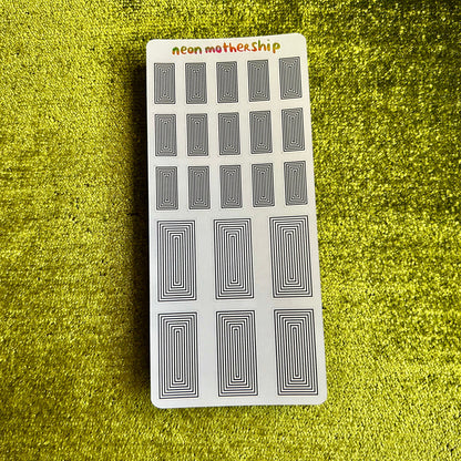 sticker sheet with black patterns on a green textured surface