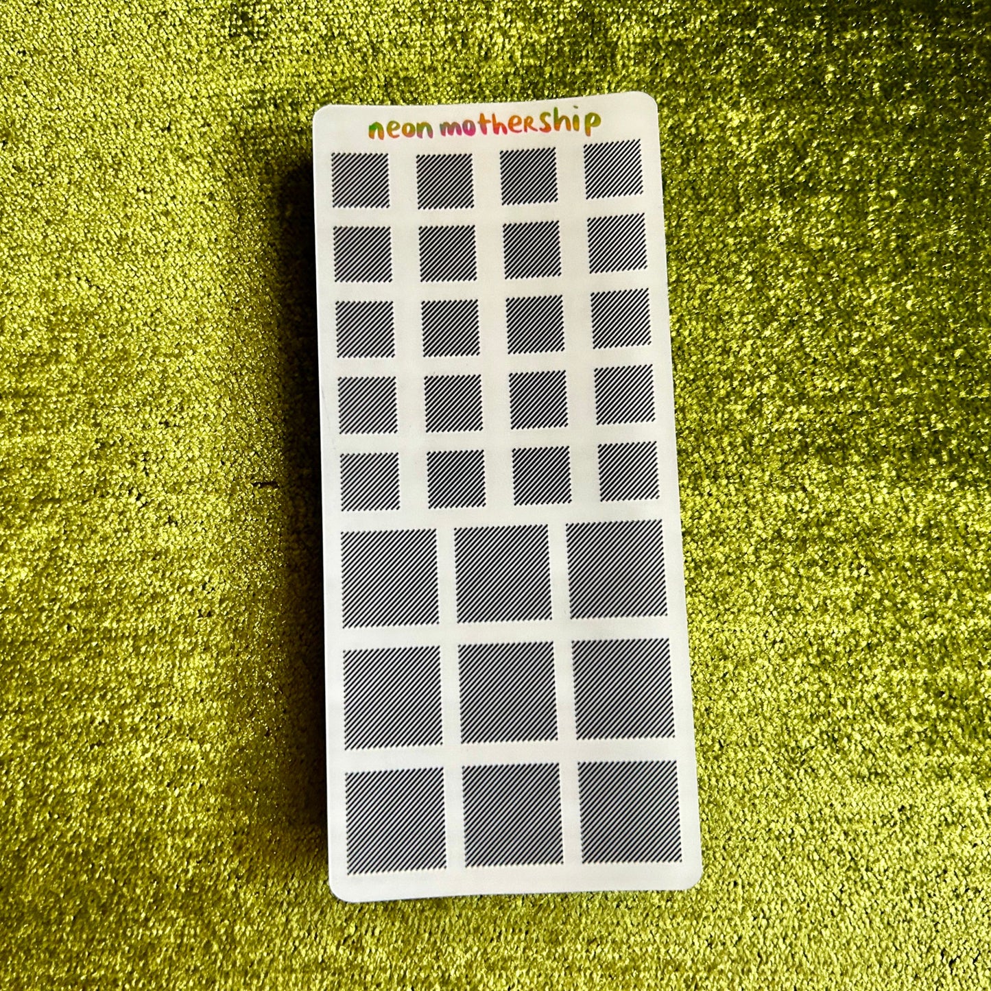 sticker sheet with grid pattern on a green textured surface