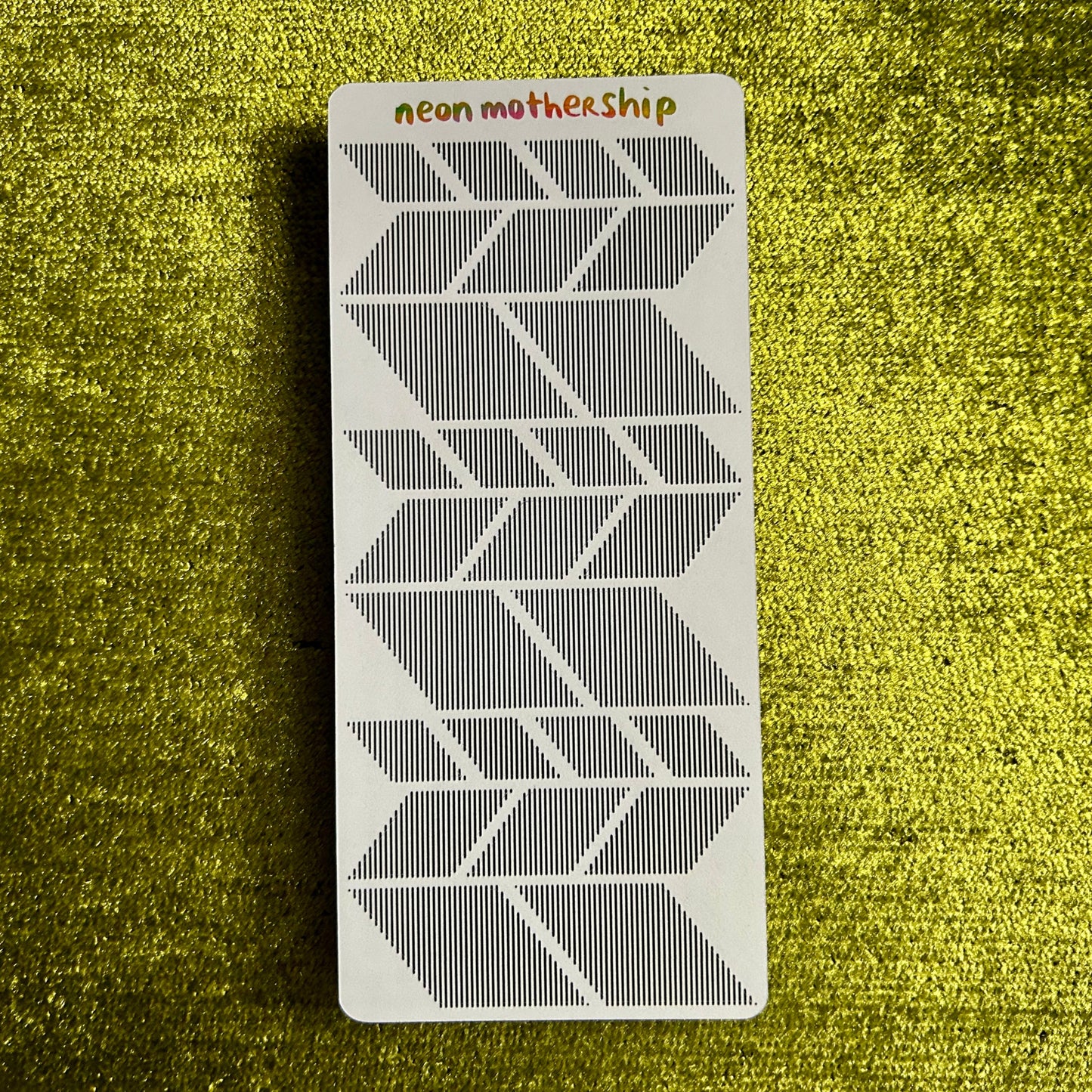 Geometric patterned sticker sheet with 'neon mothership' text on a textured green background