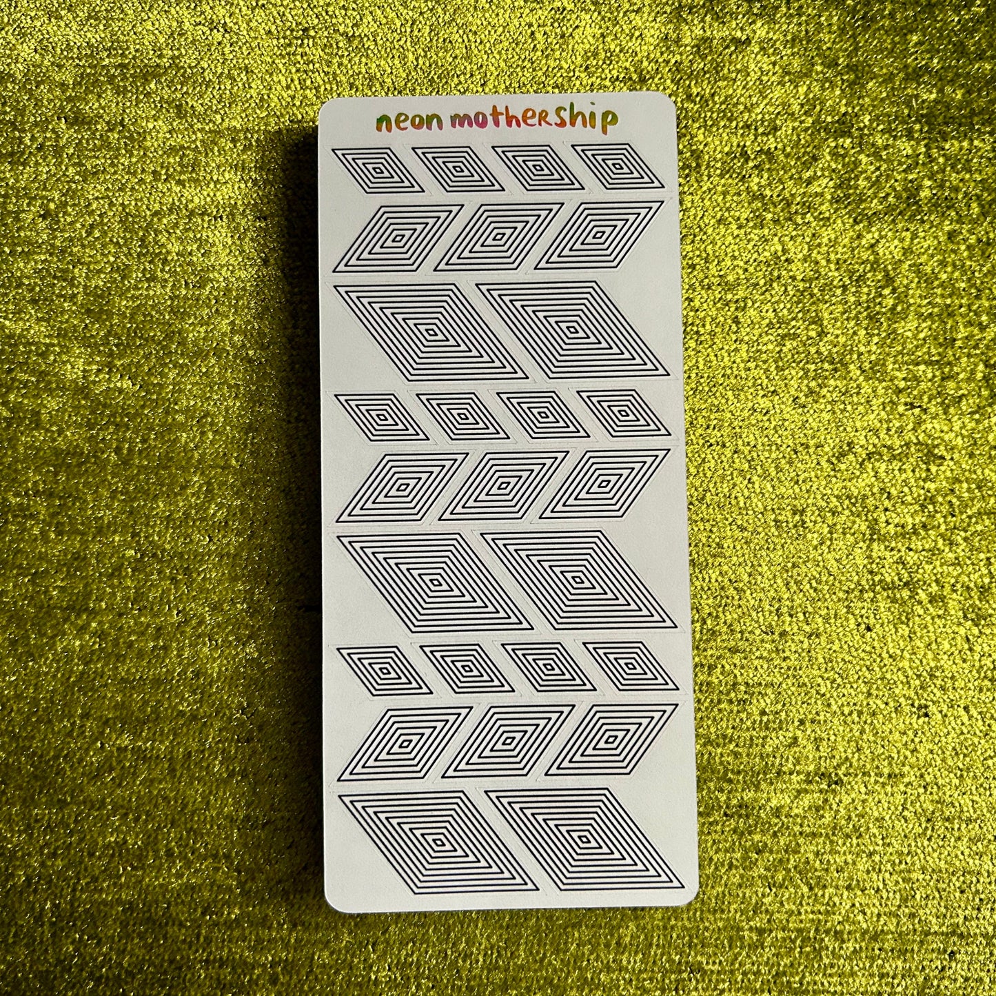sticker sheet with geometric pattern on a textured green surface