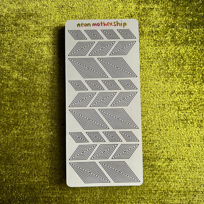 sticker sheet with geometric pattern on a textured green surface
