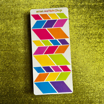 Colorful geometric patterned card on a green textured surface