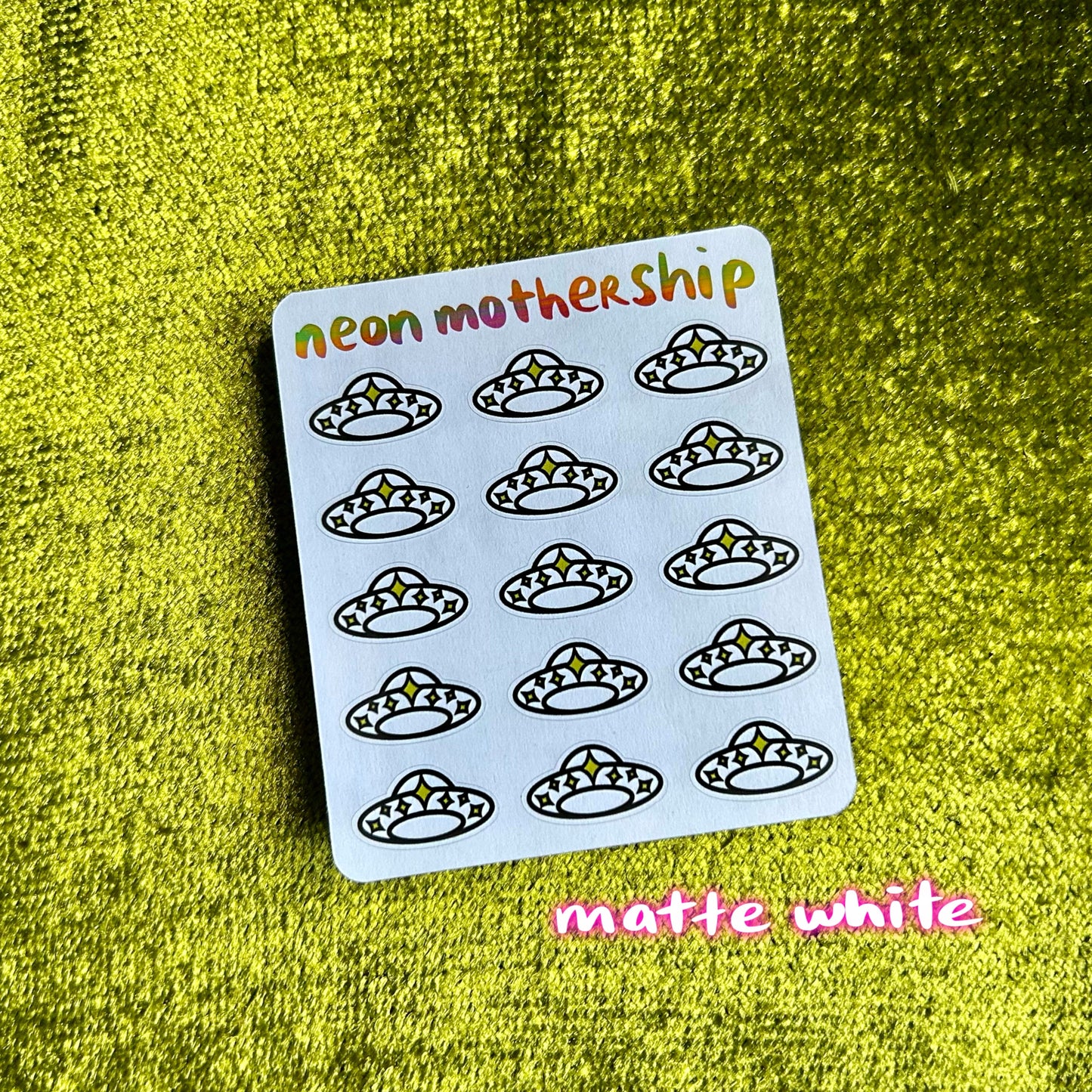 Sheet of stickers with 'neon mothership' branding on a green textured background