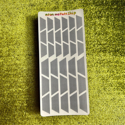 Rectangular card with geometric stickers on a green textured surface