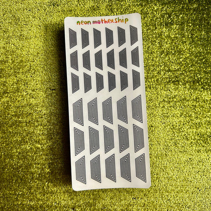 Rectangular sticker sheet with geometric pattern on a green textured background
