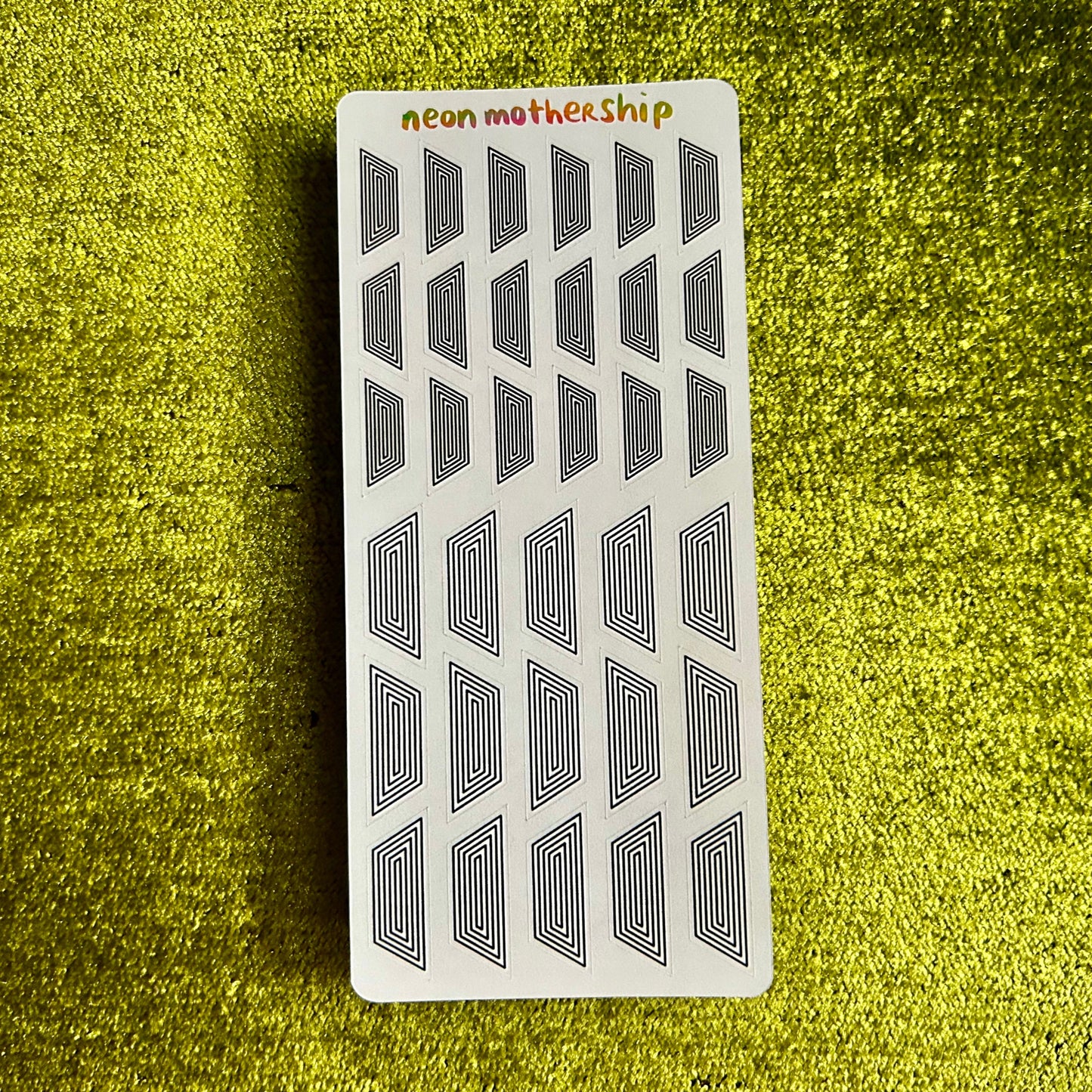 Card with geometric stickers on a textured green surface