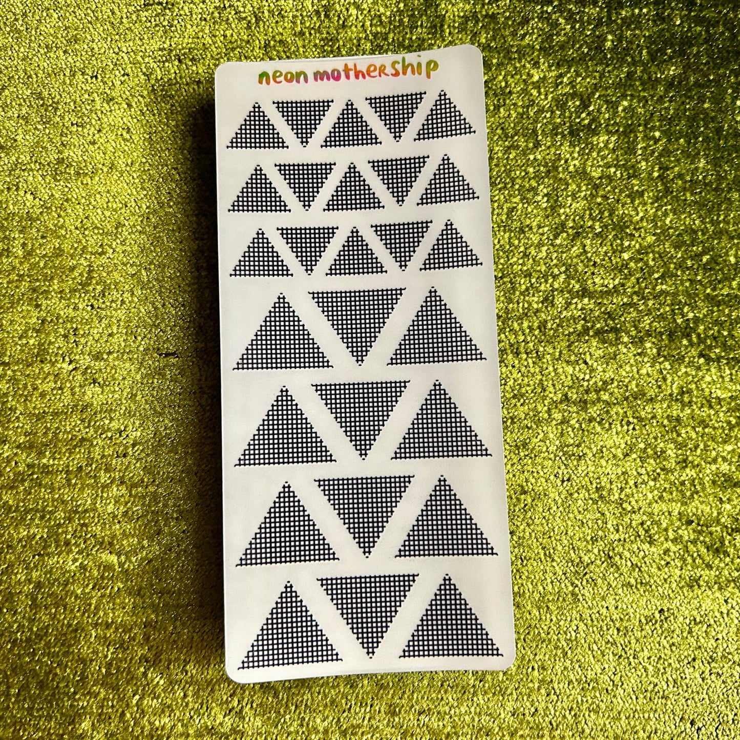 sticker sheet with geometric pattern on a green textured surface