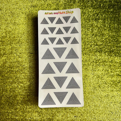 sticker sheet with geometric triangle design on a textured green surface