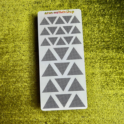 sticker sheet with triangular geometric pattern on a green textured surface