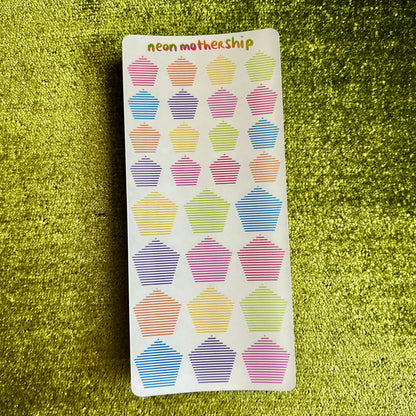 Sticker sheet with colorful pentagon designs on a green textured background