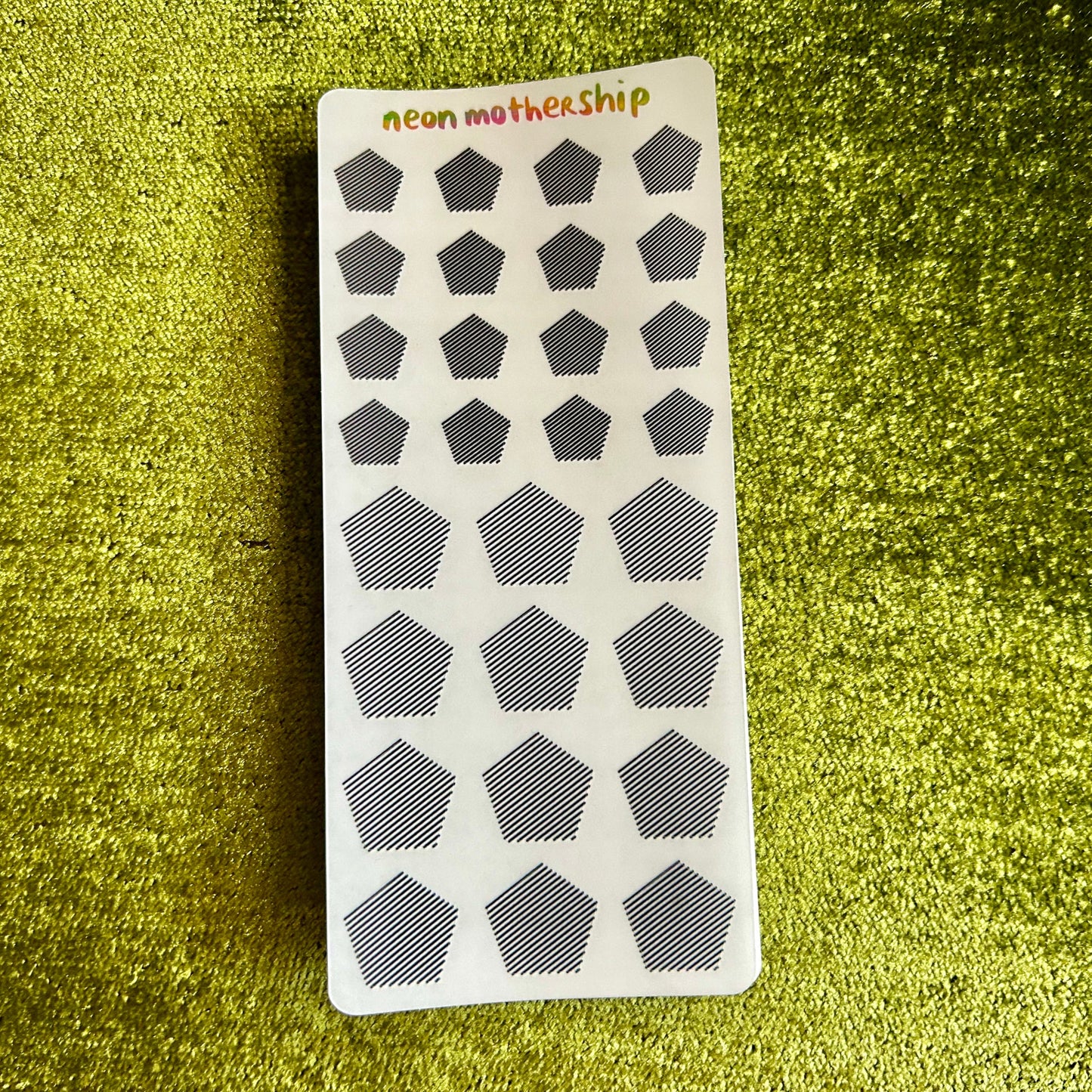 Sticker sheet with geometric shapes on a green textured background