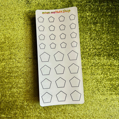 Sheet of pentagon-shaped stickers on a green textured surface