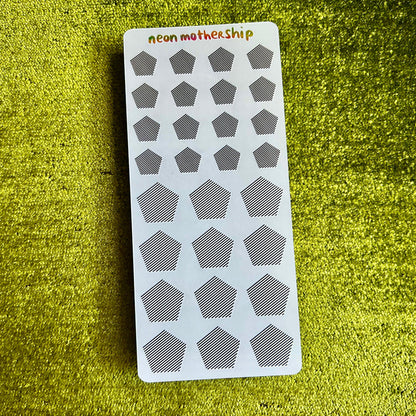 Sheet of geometric stickers with 'neon motherShip' branding on a green textured surface