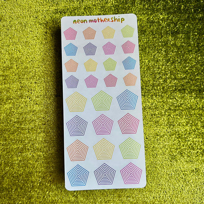Pack of colorful geometric stickers on a green textured surface