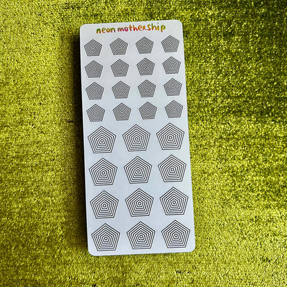 Sheet of geometric stickers on a green textured surface