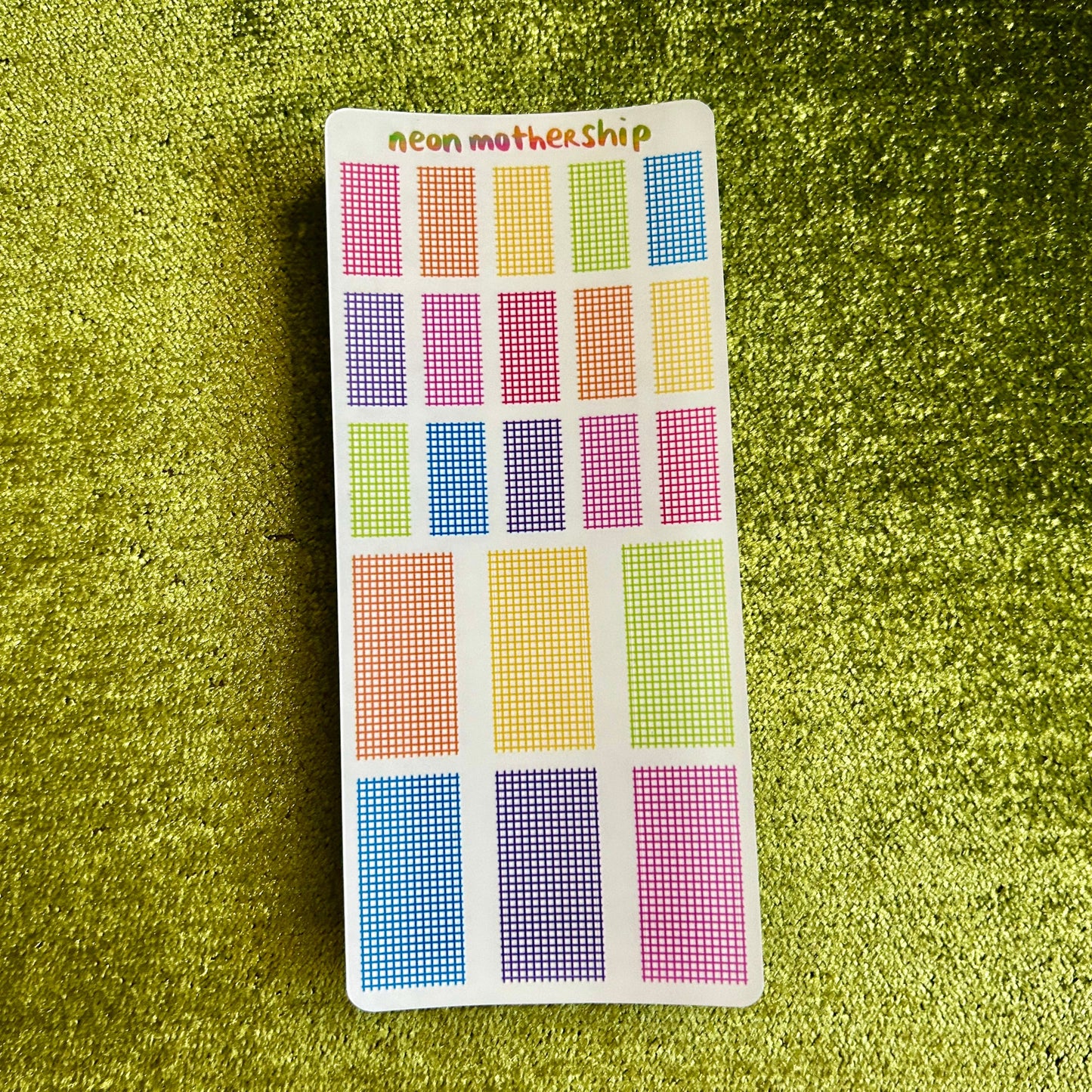 sticker sheet with grid stickers on a green textured surface