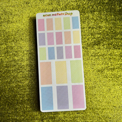 sticker sheet with pastel stickers on a green textured surface