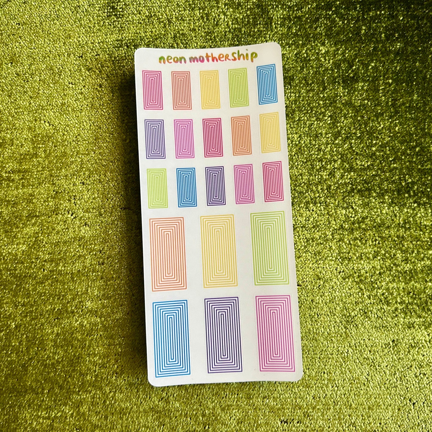 Pack of colorful rectangular stickers on a green textured background
