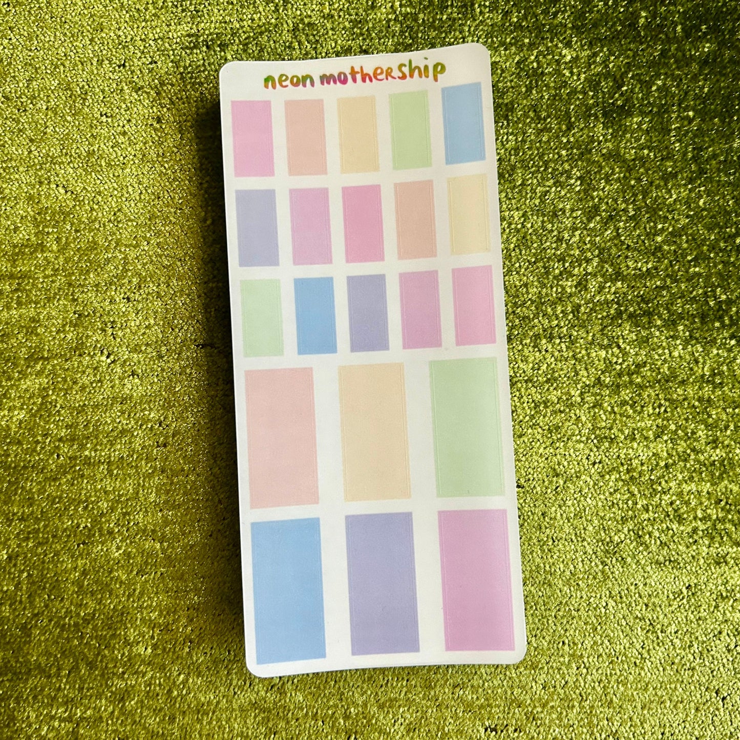 sticker sheet with pastel rectangles on a green glittery background