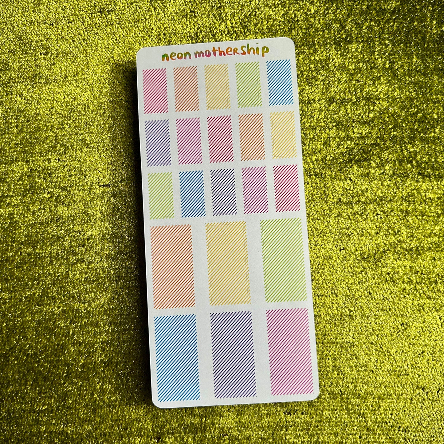 sticker sheet with pastel rectangular stickers on a green textured surface