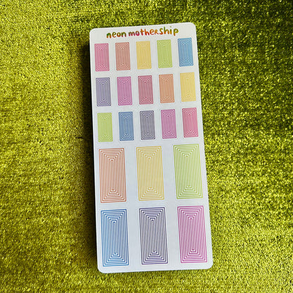 Pack of colorful rectangular stickers on a green textured background