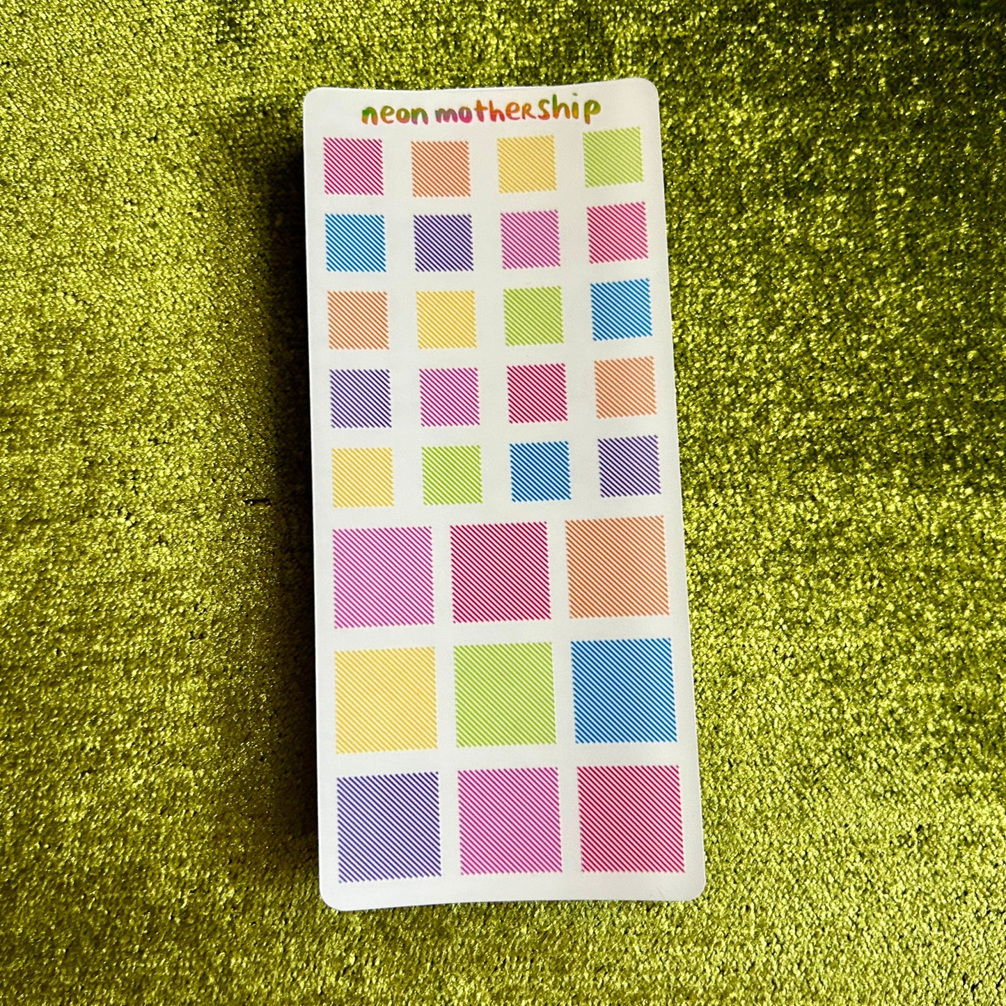 sticker sheets with square stickers on a green textured background